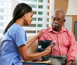 A caregiver measuring the blood pressure of a patient