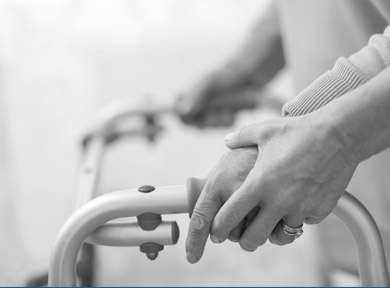 Hands of a person guiding someone's hands while using a walking aid